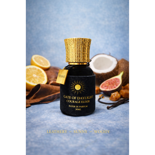 Luxuriöser schwarzer Flakon des Courage Elixiers mit goldener Kappe, umgeben von Zitronen, Kokosnuss und Feigen – Exklusives Nischenparfum von CHASAL